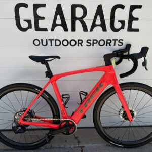 The Domane+, bright red, in front of the Gearage's storefront.