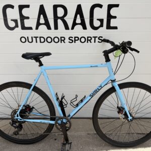 A Blue Surly Preamble bicycle in front of the Gearage's garage door